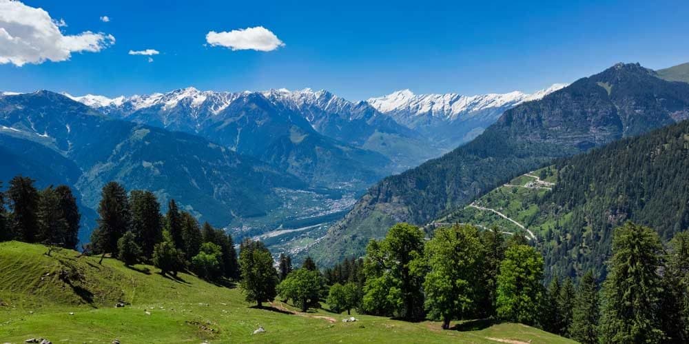 Green Kullu valley with snow-capped Himalayan peaks near Manali, Himachal Pradesh
