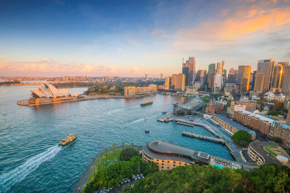 Sydney Opera House and the harbour skyline at sunset